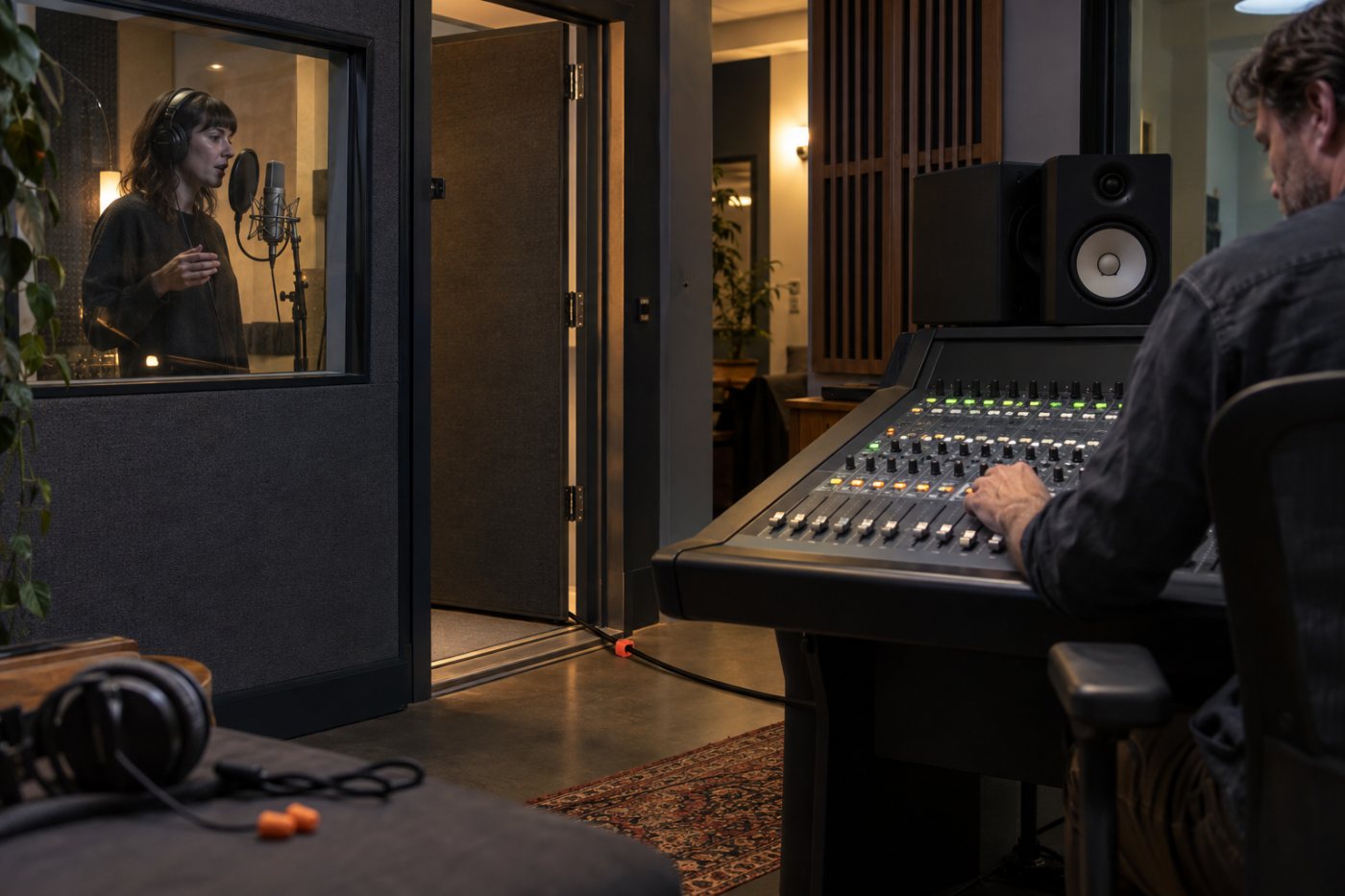 Eine Aufnahme im Tonstudio und die Arbeit an einer Fairlight-Konsole zeigen den Audiopart einer Videoproduktion mit Spezialisten.