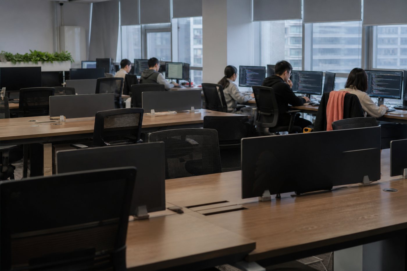 Redução de uma equipe de programação em Pequim deixa postos vazios enquanto o trabalho técnico continua com IA.