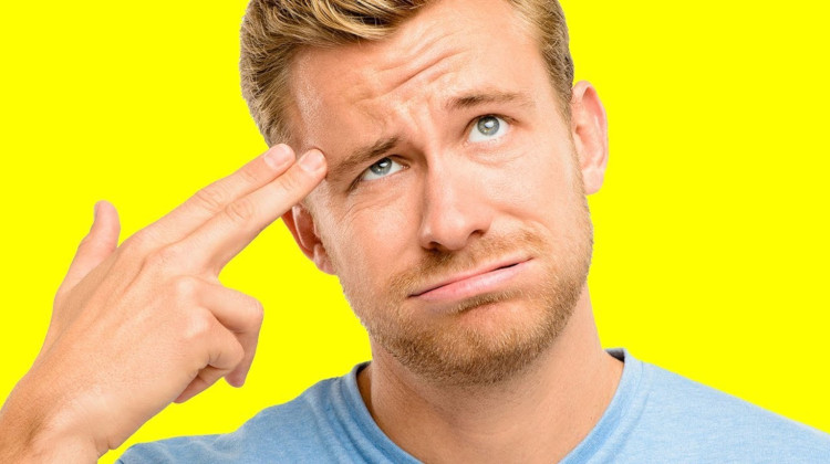 чел на жёлтом фоне приставил два пальца к виску