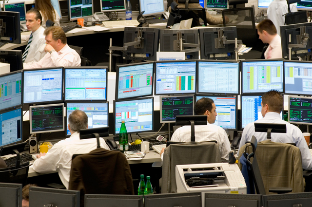 Мужчина работает за компьютером на столе, монитор отображает информацию.