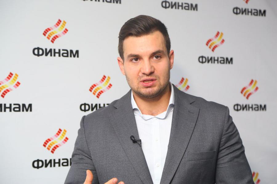 Мужчина в костюме на пресс-конференции с толпой взрослых людей.