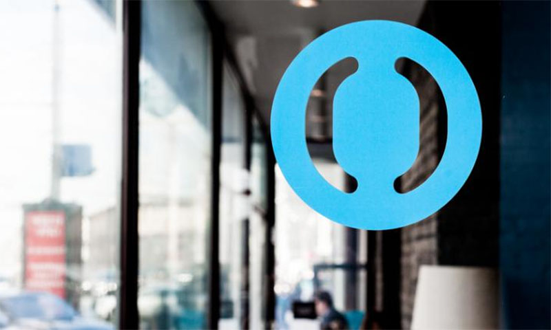 Городской пейзаж с человеком, держащим символическую ленту на фоне города.