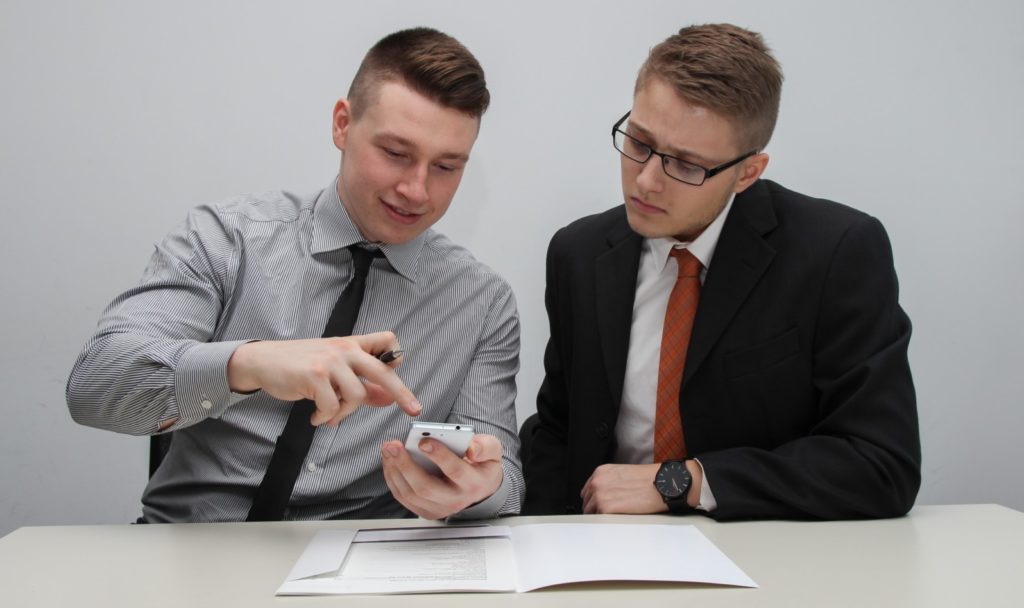 Мужчина в офисном костюме с галстуком и выразительным лицом.