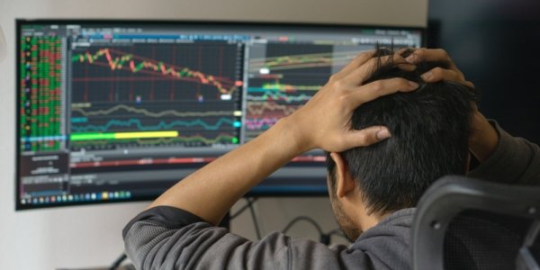 Человек за компьютерным монитором в офисном кресле - железо и электроника.