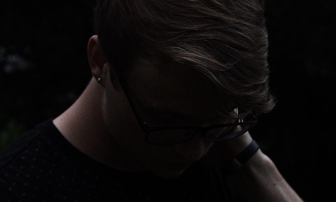 Фотография портрета взрослого мужчины с серьгой, выделяющегося лицом и шеей.