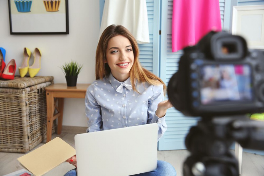 Фотография человека в высоких каблуках с улыбкой, делающего сэлфи на ноутбуке.