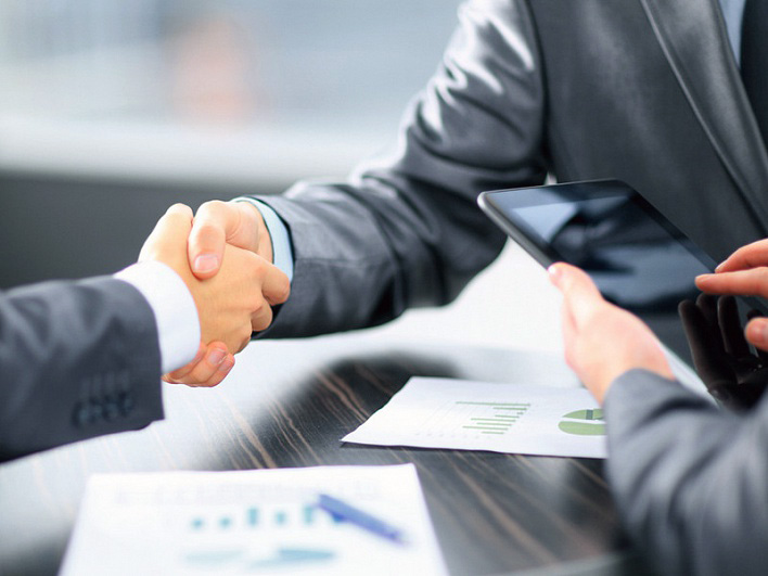 Фото взрослого мужчины с мобильным телефоном в руке, на фоне текста.