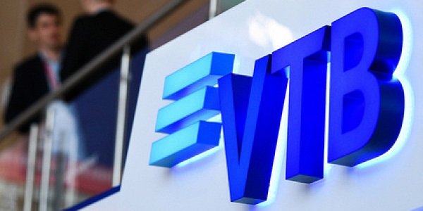 Человек с логотипом, текстом и символом на фоне.