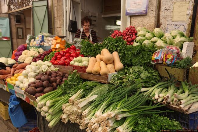 Человек с сумкой на фермерском рынке выбирает аксессуары.