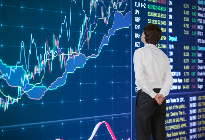 Взрослый мужчина стоит перед доской с графиком в руках.