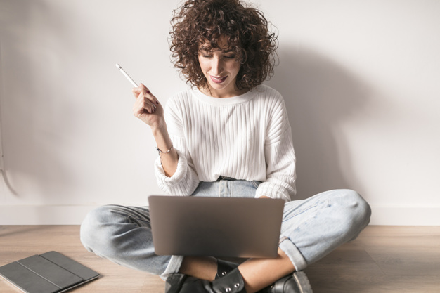 Человек сидит за ноутбуком, сосредоточенно смотрит на экран компьютера.