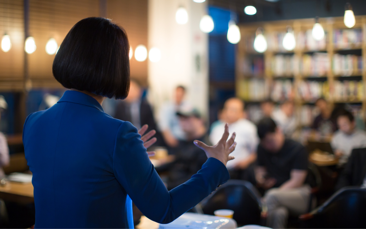 Взрослая женщина и мужчина с детьми в толпе людей в помещении.