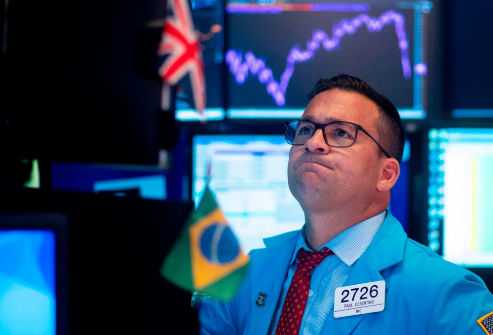 Мужчина в галстуке с очками работает за компьютером, на мониторе - портрет.