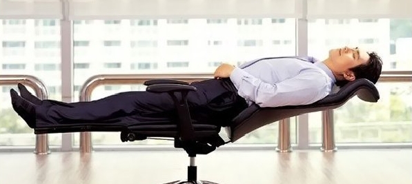 Мужчина спит на стуле в помещении в одежде и перчатках.