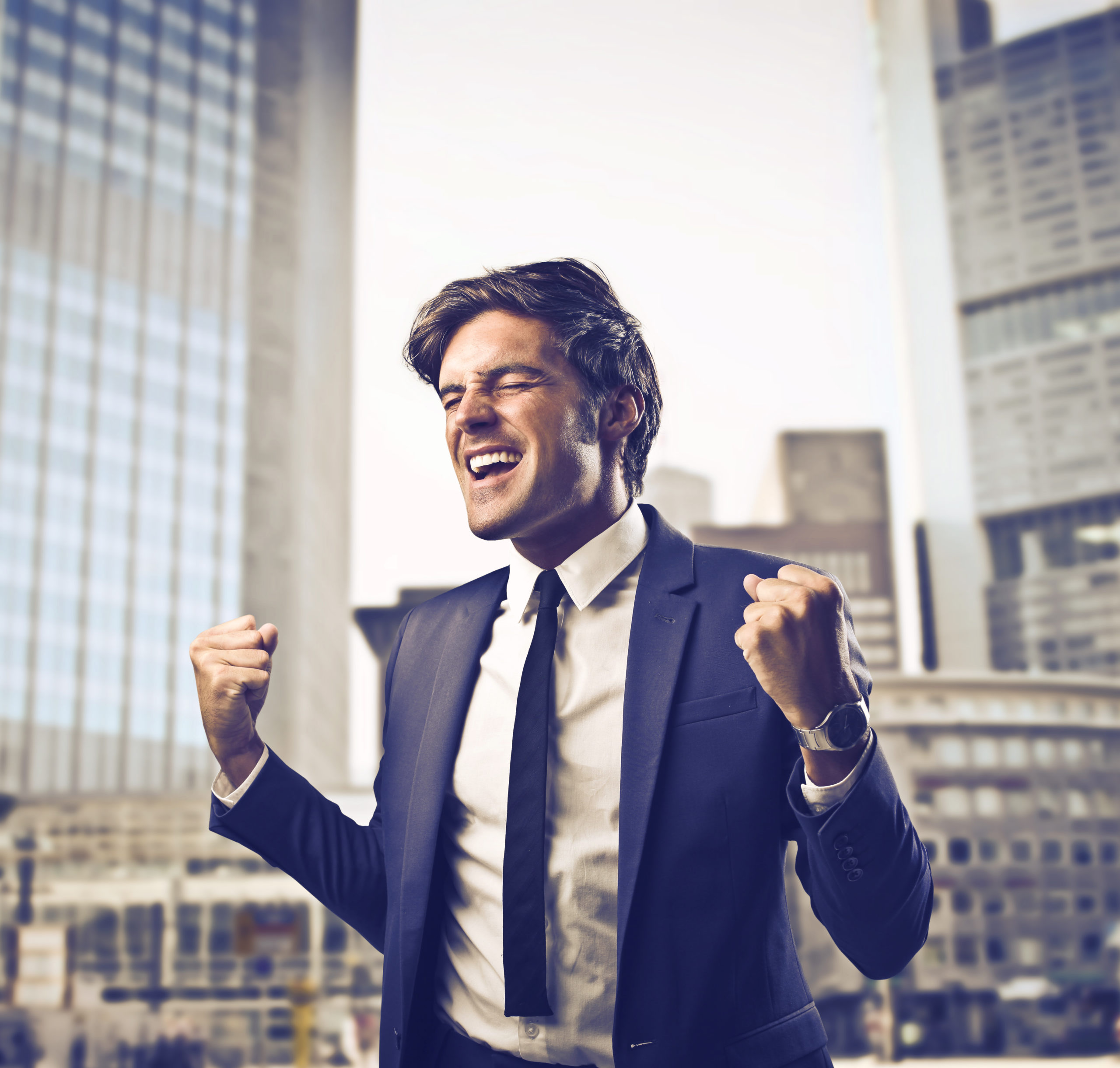 Счастливый мужчина в галстуке, смеющийся, с улыбкой на лице.