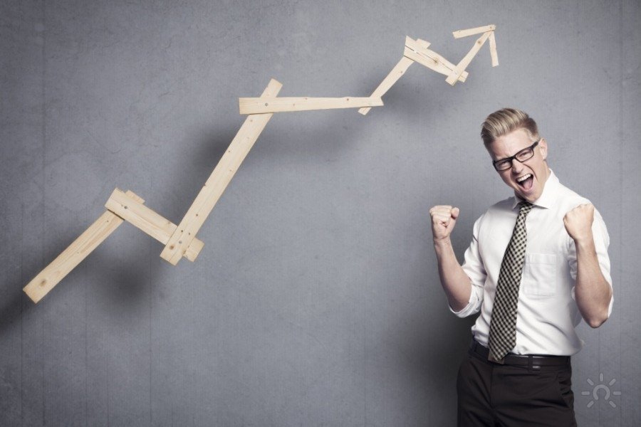 Мужчина в формальной одежде: рубашка, галстук, очки, сидит на мебели.