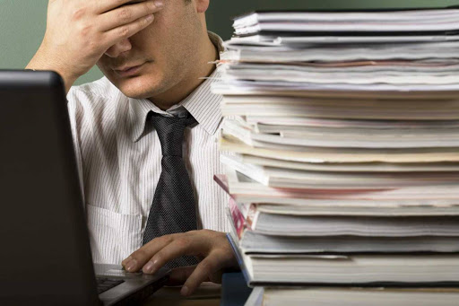 Мужчина в офисной одежде с ноутбуком, ПК на фоне, электроника.