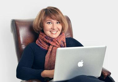 Фотография человека с ноутбуком, рядом электроника, компьютер, одежда, шарф.