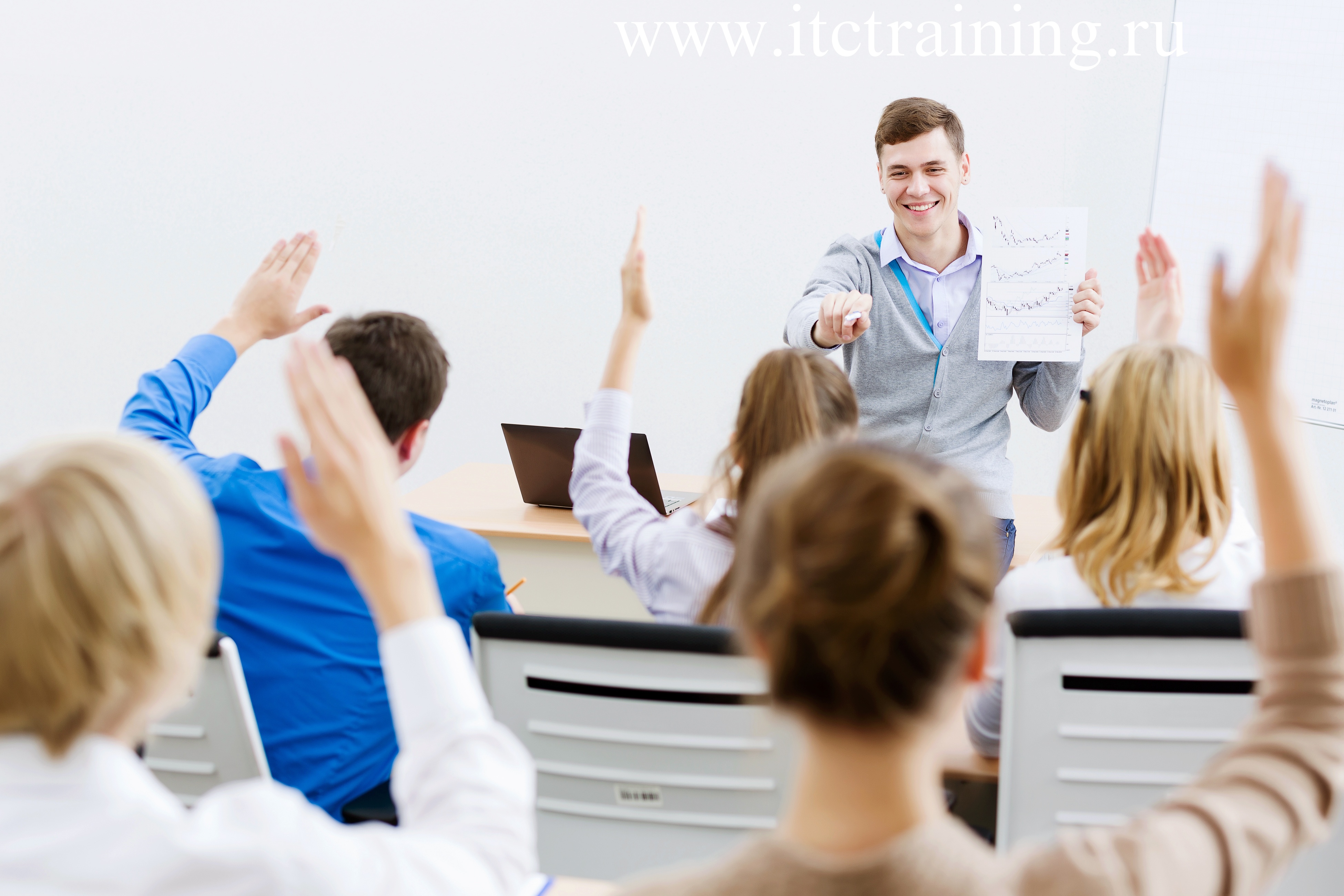 Женщина с ноутбуком и ручкой представляет презентацию у доски.