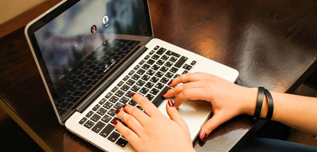 Ноутбук с компьютерной клавиатурой на руке человека, электроника и украшения.