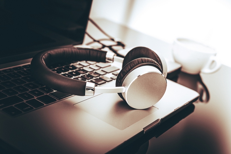 Электроника: ноутбук, компьютер, наушники, кофе в чашке. ПК и напиток на столе.