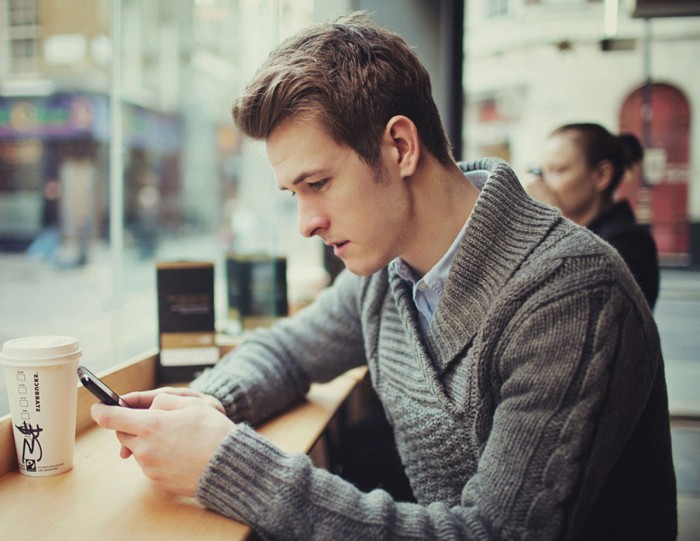 Женщина с серьгами, глядящая на подростка с одноразовым стаканчиком кофе.