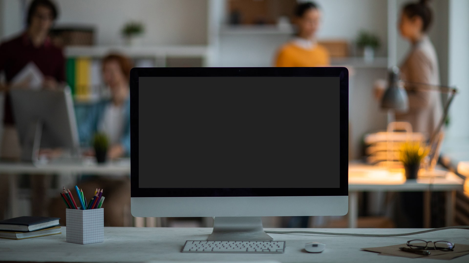 "Modern computer hardware setup on a desk with monitor, keyboard, and electronics."