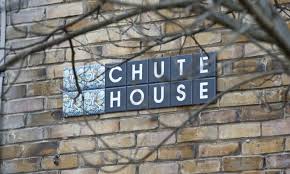 "Exterior brick wall of an architectural building with a sign and scoreboard symbol"