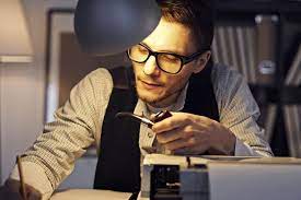 Мужчина в очках и жилете с трубкой, держит аксессуары, курительная трубка.