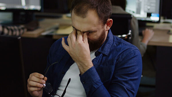 Мужчина взглядывает на грустный экран монитора, выражение лица выражает печальность.