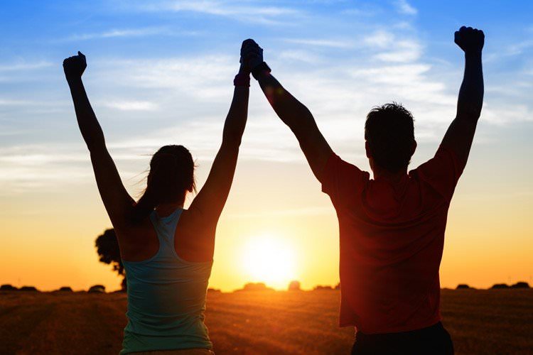 Фотография счастливого и триумфального мужчины с открытым небом на заднем плане.