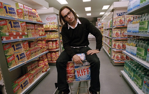 Человек в магазине с продуктами на полках внутри продуктового магазина.