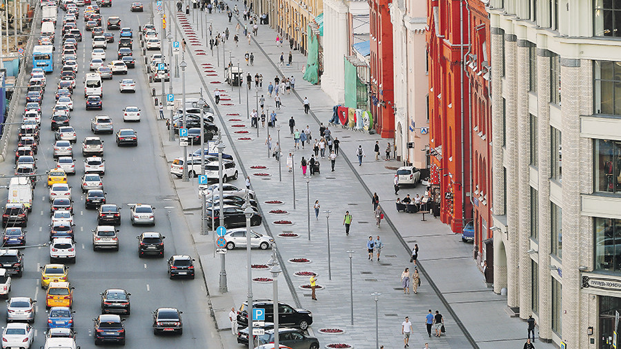 Городская дорога с автомобилями и пешеходами в современном мегаполисе.