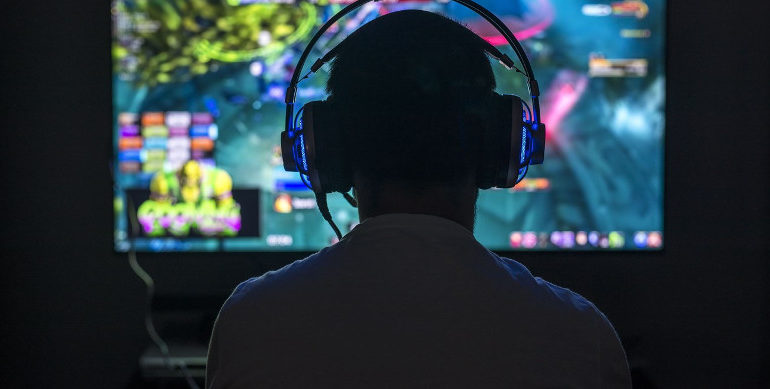 Электроника: персона в наушниках, играющая в видеоигры. (Electronics: Person in headphones gaming.)