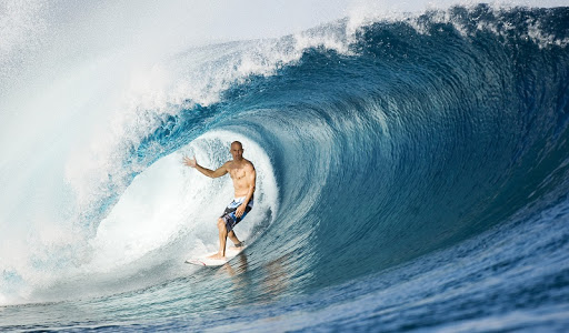Мужчина-серфер на фоне морской волны, естественная красота и активный отдых.