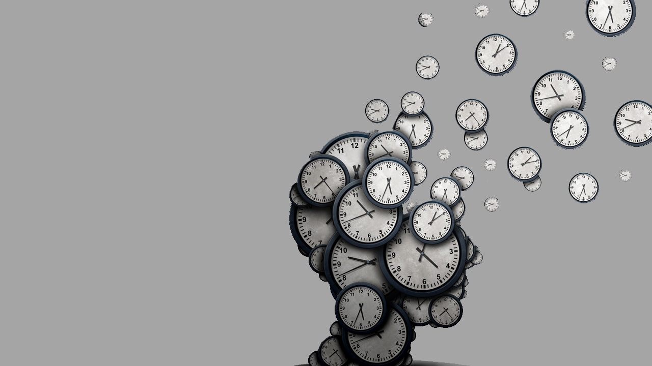 Аналоговые часы на запястье человека, рядом с футбольным мячом у башни с часами.