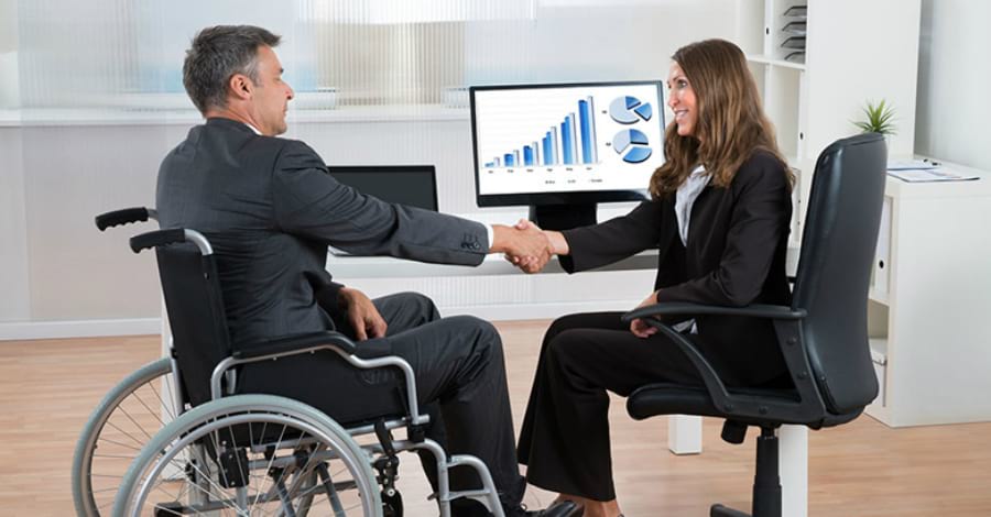 Взрослая женщина и мужчина сидят на стульях перед монитором.