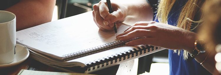 Человек пишет с карандашом в чашке - оптимизированный ALT текст для изображения.