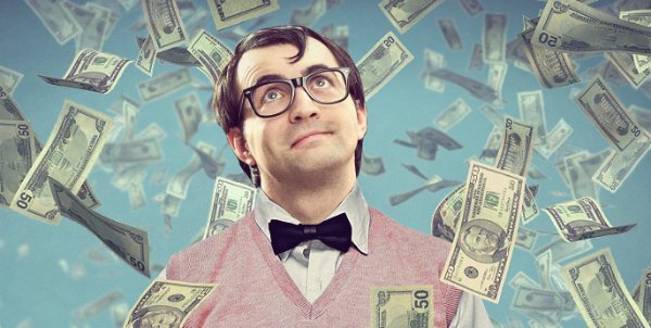 Взрослый мужчина в деловом костюме с галстуком, держащий доллары.