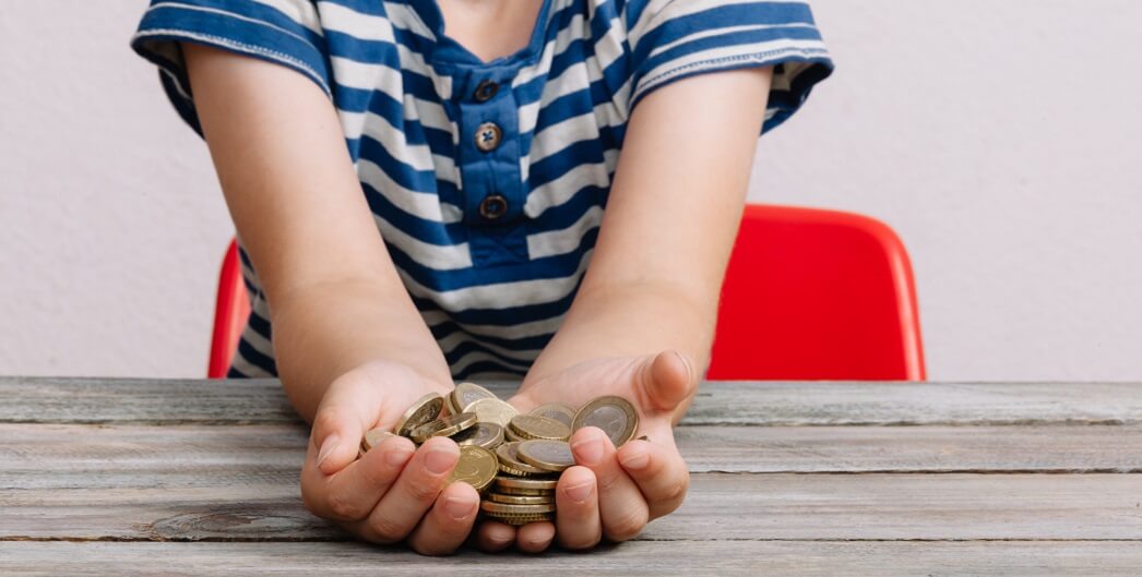 Мальчик-ребенок с монетой в руках - изображение с деньгами и монетой.