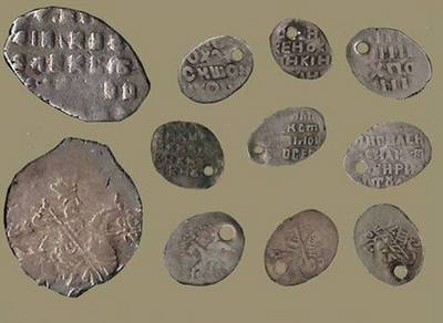 Бронзовая и серебряная монета с денежной купюрой и трубкой для курения.