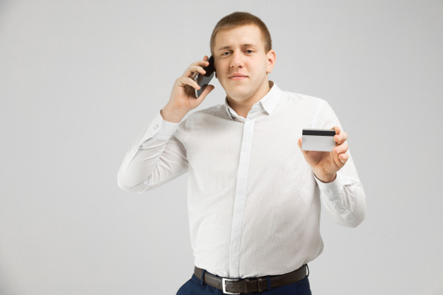 Фотография мужчины смартфоном, платежной картой, в рубашке. (Translation: "Photo of a man with smartphone, credit card, in a dress shirt.")