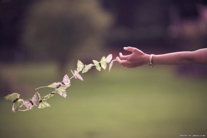 Браслет ювелирные украшения на пальце руки человека на траве рядом с листом и ребенком.