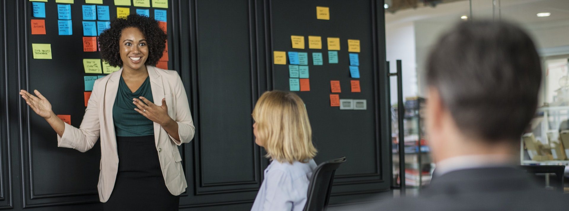 Взрослая женщина и девочка в разговоре, одетые в пальто, стоят на фоне.