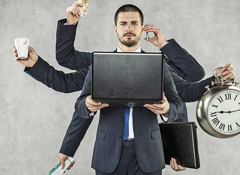 Человек с головой у белой доски, работающий за ноутбуком и компьютером.