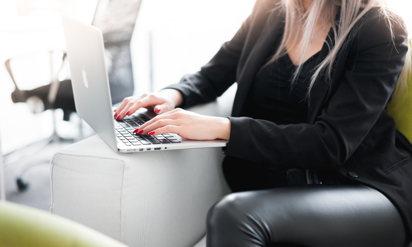 Женщина-взрослая персона, сидящая за ноутбуком, работает на компьютере и нажимает на клавиши.