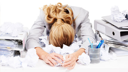 Взрослая женщина в медицинском халате перед зданием больницы.