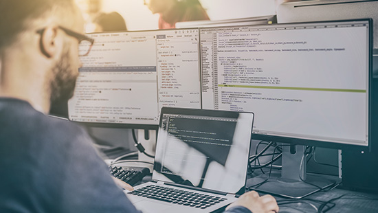 Ноутбук на фоне белой доски с мужчиной, клавиатурой и монитором.