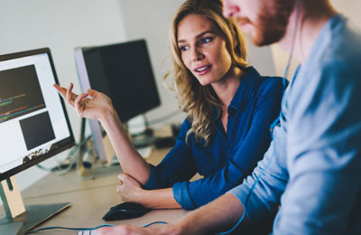 Человек смотрит на компьютерный монитор с электроникой, аппаратурой и железом.