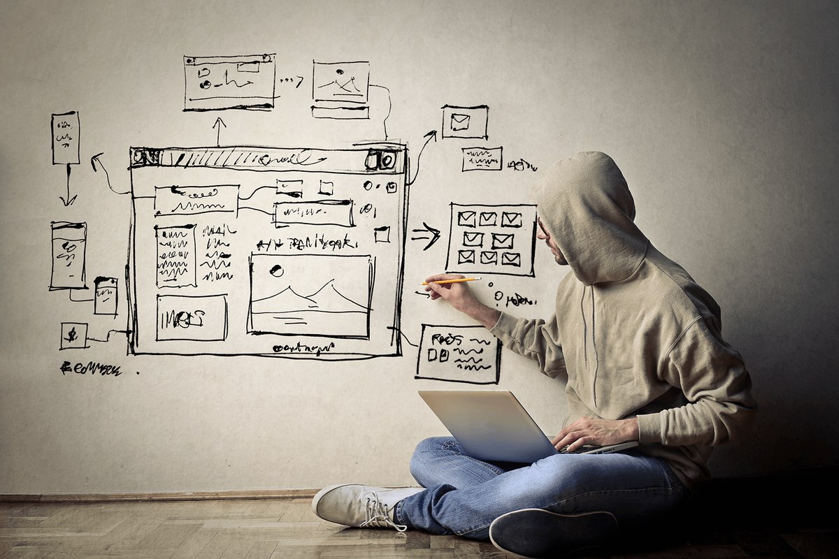 Взрослый мужчина с ноутбуком, обувью, схемой на фоне, мужское лицо.